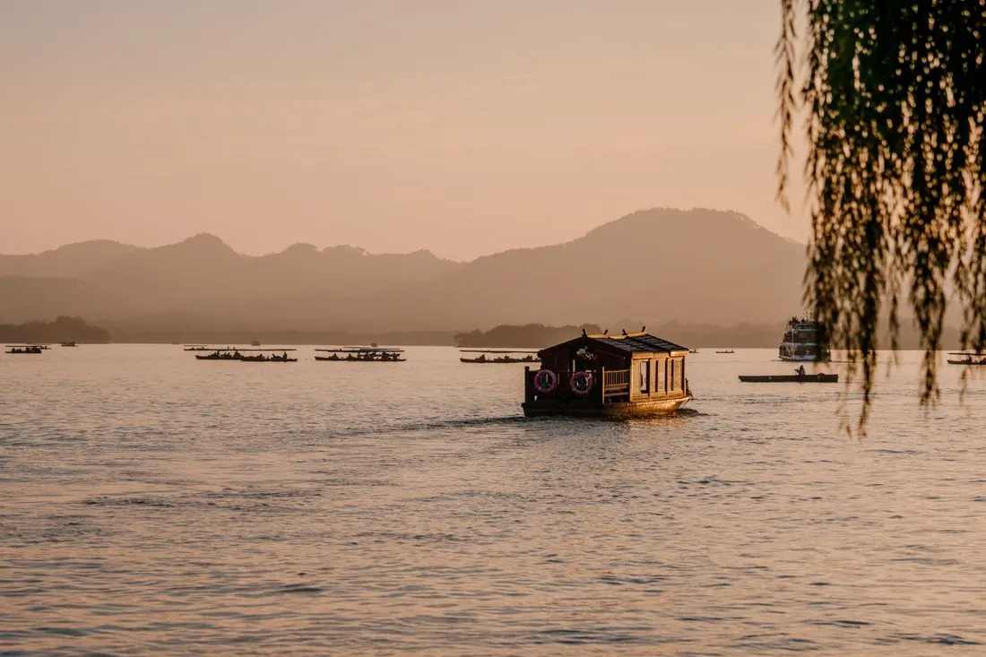 A traditional Kerala houseboat cruising the Alleppey backwaters at sunset